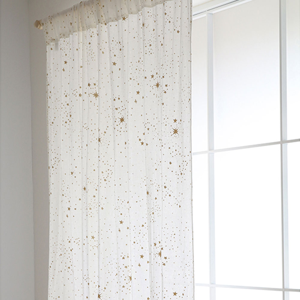 Der Nobodinoz-Vorhang "Utopia" mit goldenen Sternen in weiß hilft, das Schlafzimmer etwas abzudunkeln.